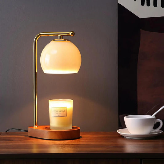Glass globe candle warmer with gold metal arm and dark round base