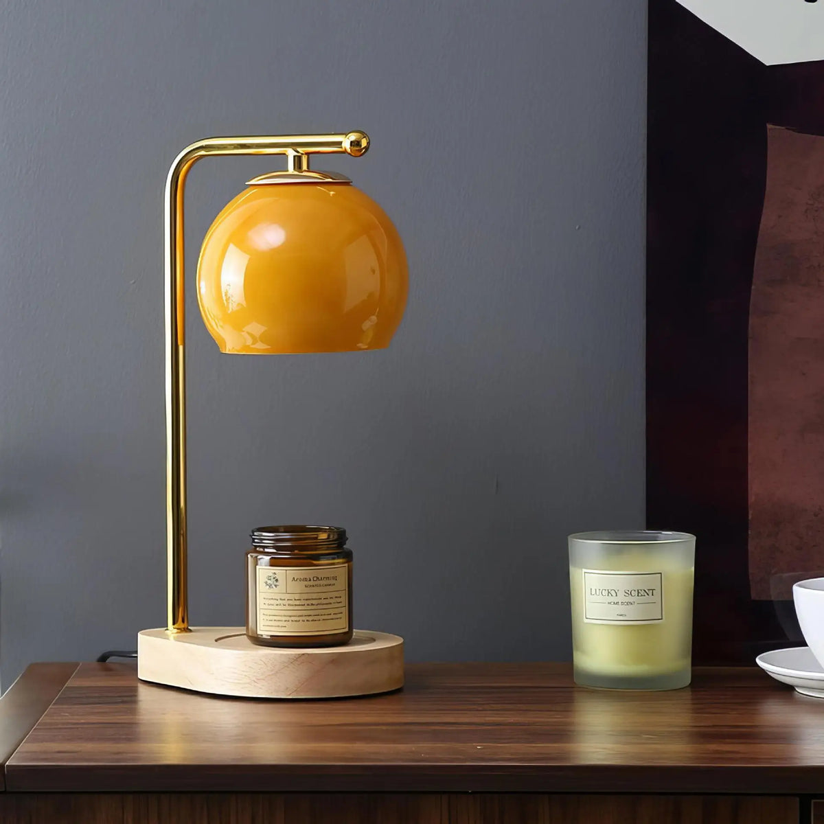 Amber glass candle warmer above a jar candle on a pale base