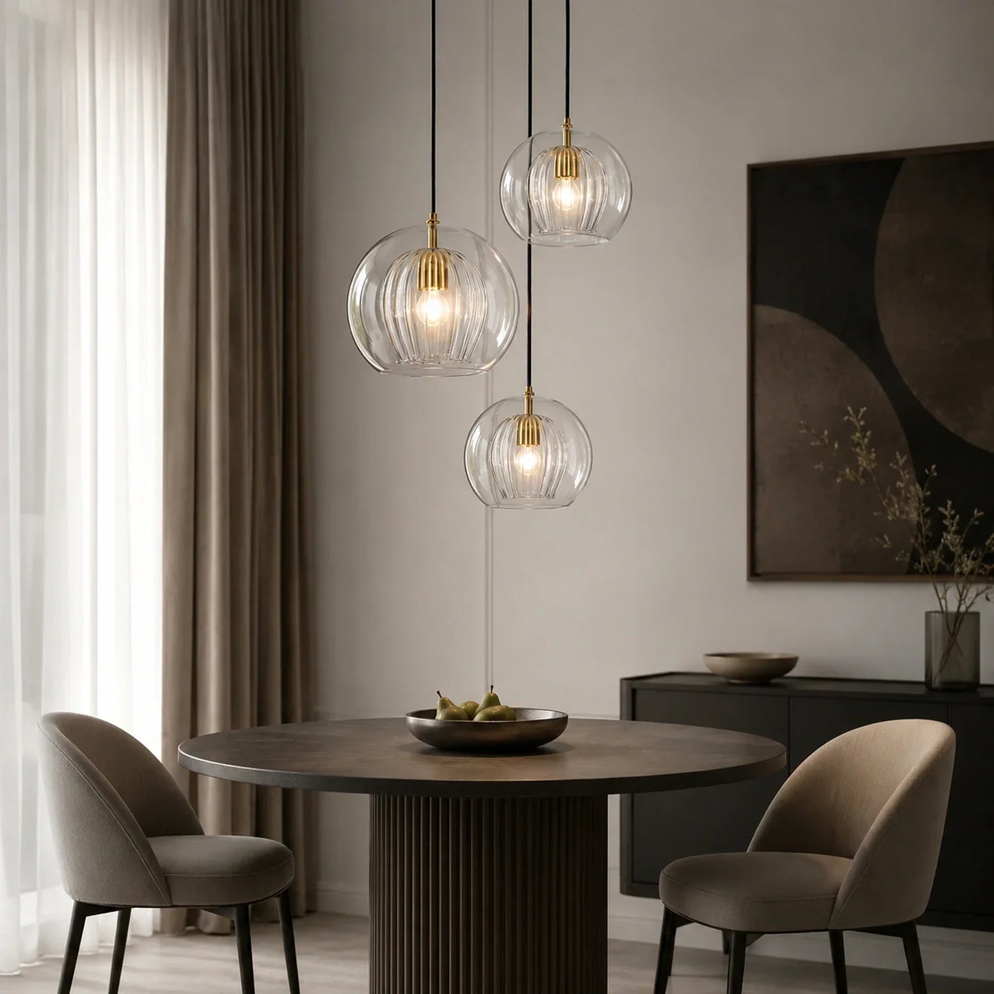 Three contemporary ribbed glass globe pendant lights with brass fittings hanging above a round dining table in a modern, neutral-toned dining room.