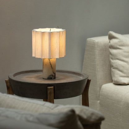 Cordless marble table lamp illuminated beside a sofa