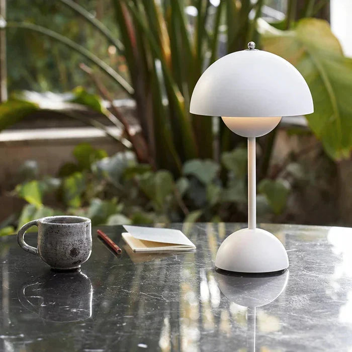 White dome table lamp beside a cup and book