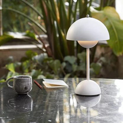 White dome table lamp beside a cup and book