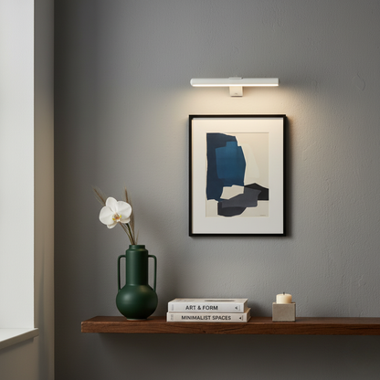 White picture light above a framed print and console shelf