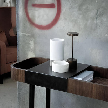 Black cordless table lamp on a side table beside white accessories
