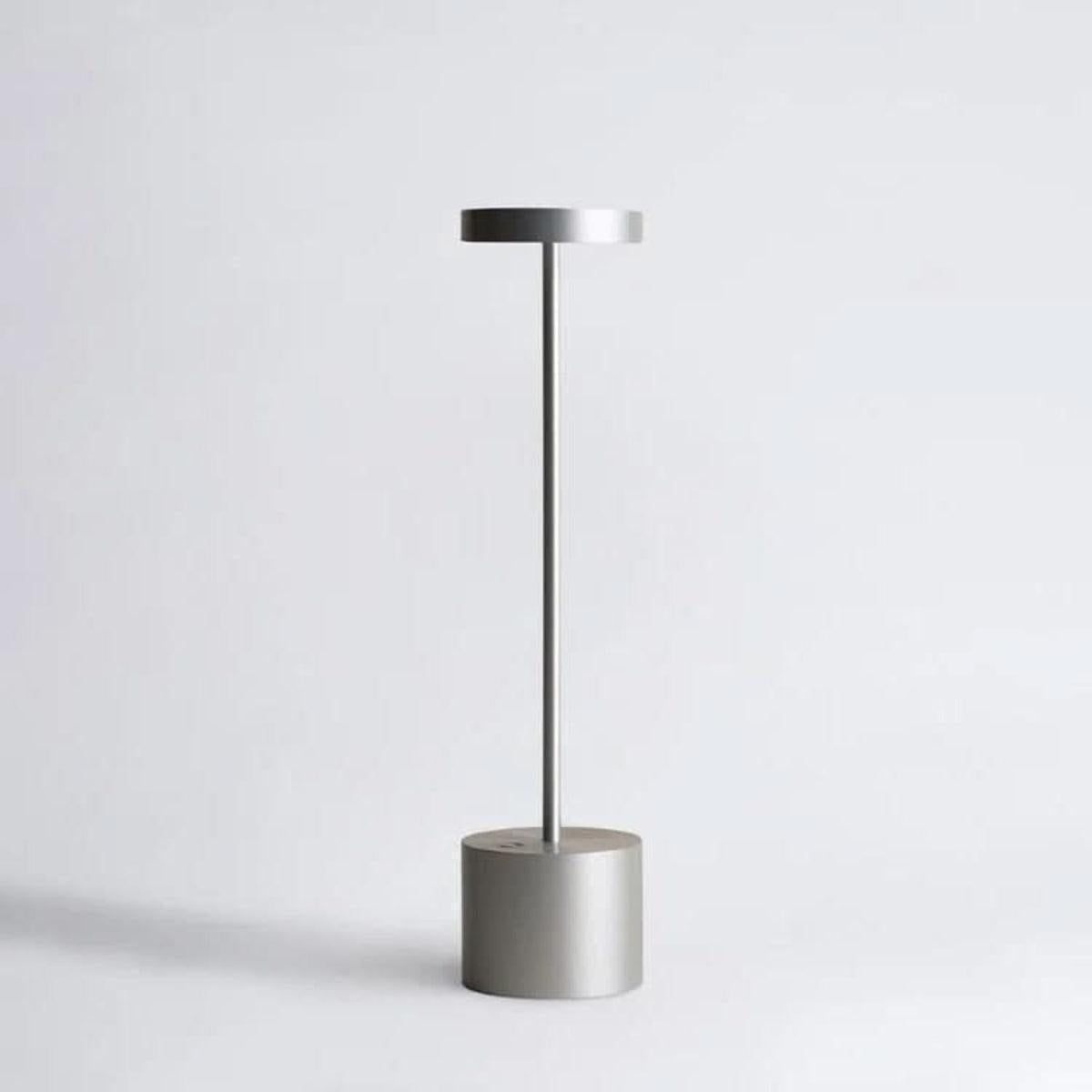 Silver cordless table lamp with a cylindrical weighted base
