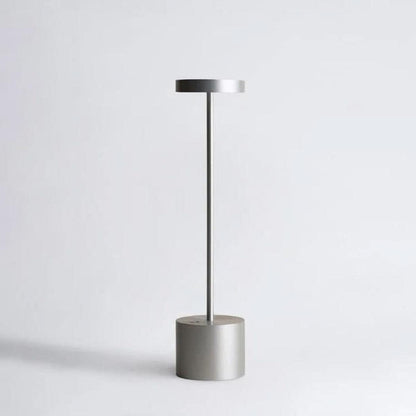Silver cordless table lamp with a cylindrical weighted base