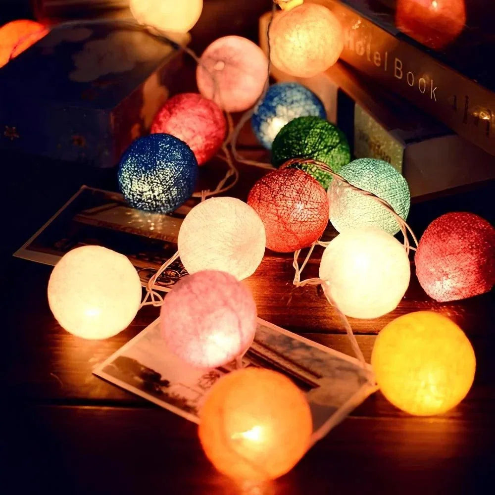 Multicolour cotton ball lights arranged beside books