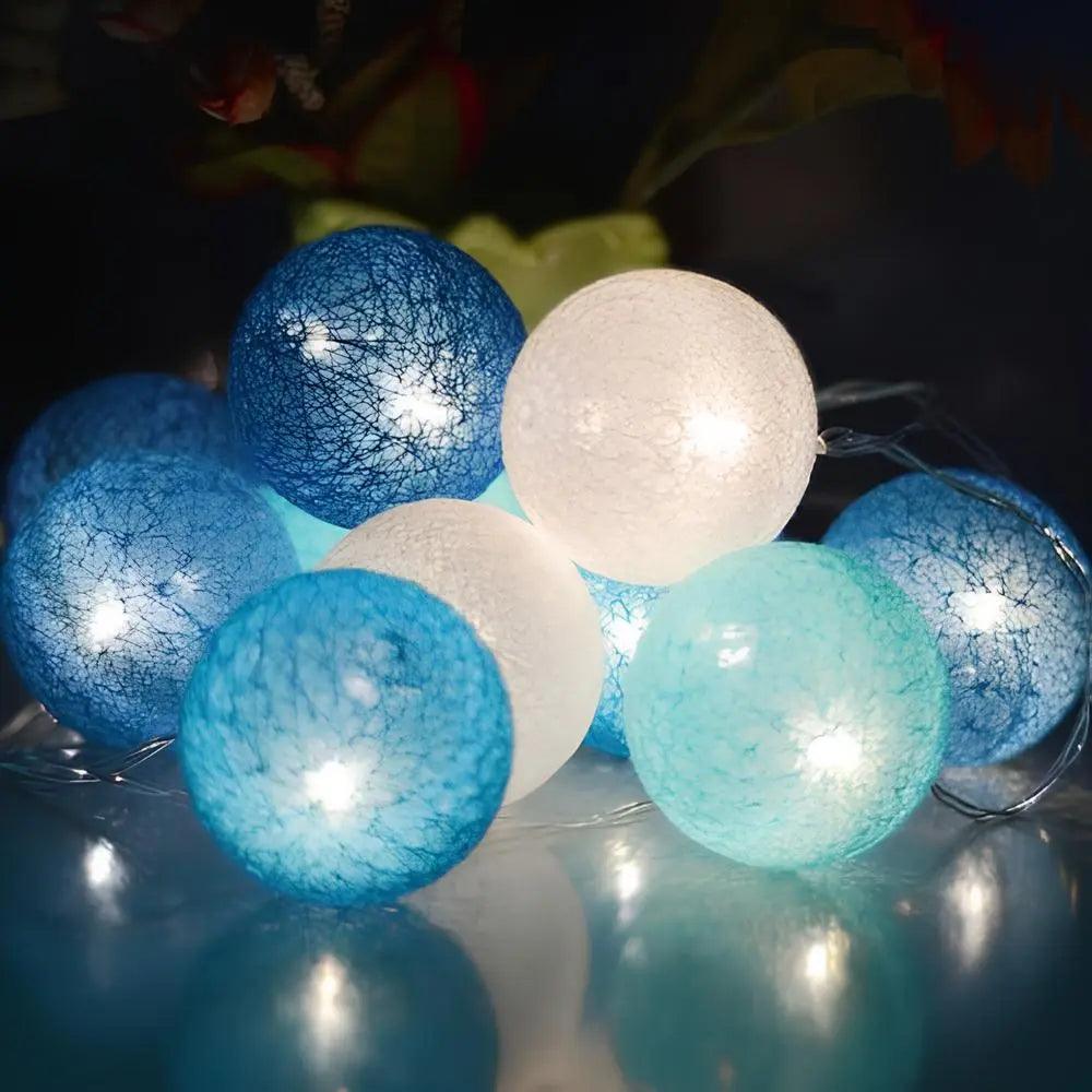 Blue and white cotton ball lights glowing on a table