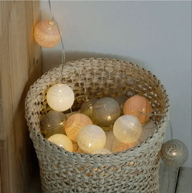 Pink, grey and white cotton ball lights in a woven basket