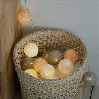 Pink, grey and white cotton ball lights in a woven basket