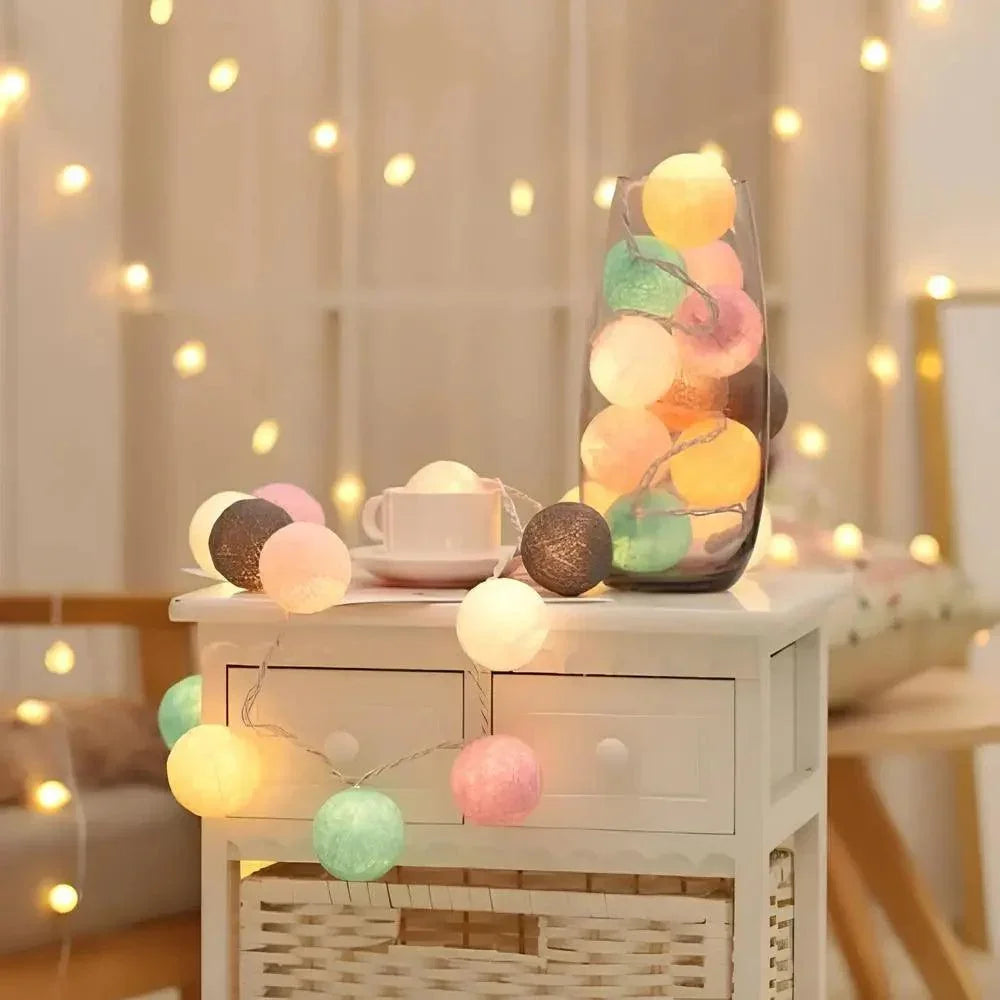 Cotton ball light garland draped across a bedside cabinet