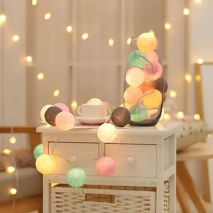 Cotton ball light garland draped across a bedside cabinet