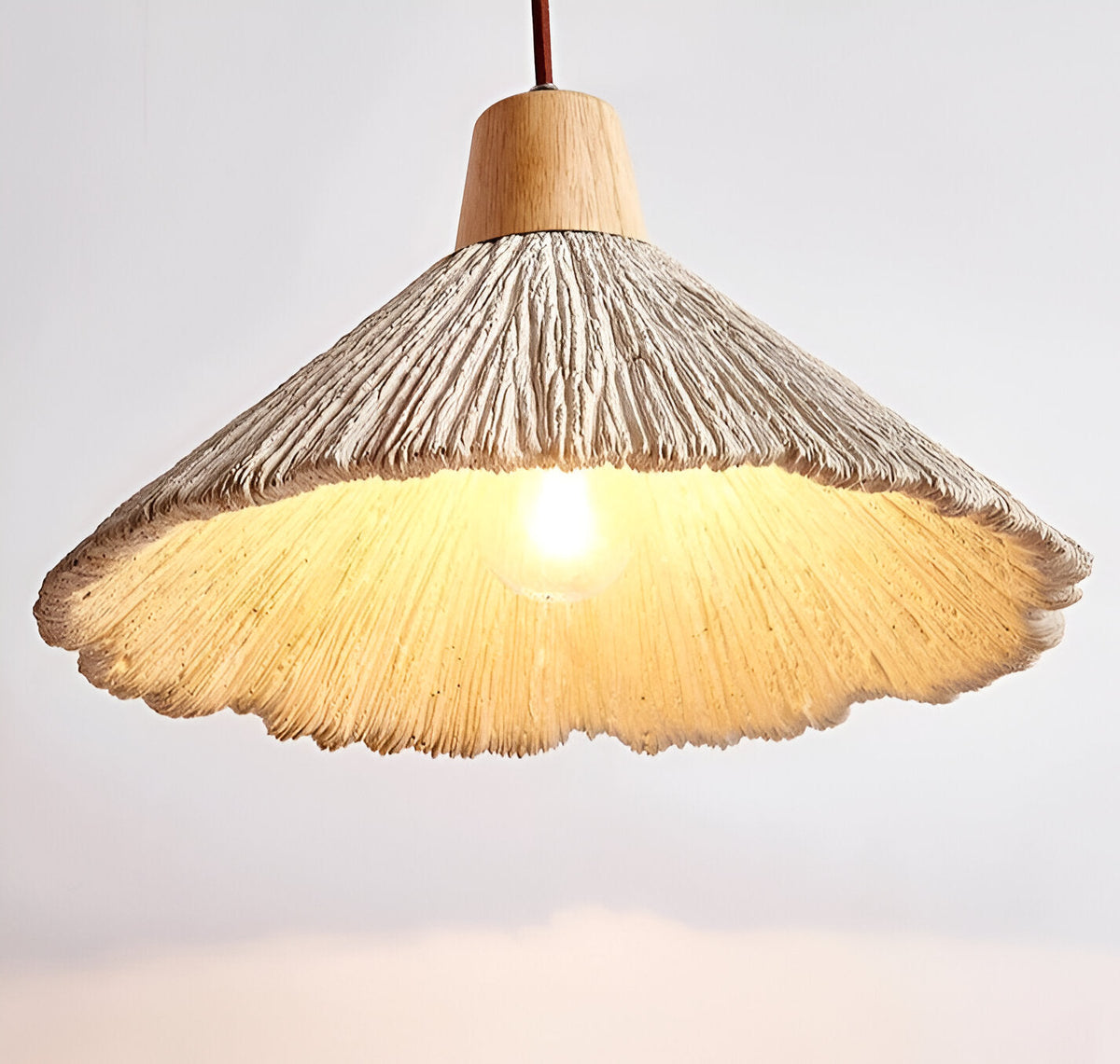 Underside of wide cream pendant with warm bulb