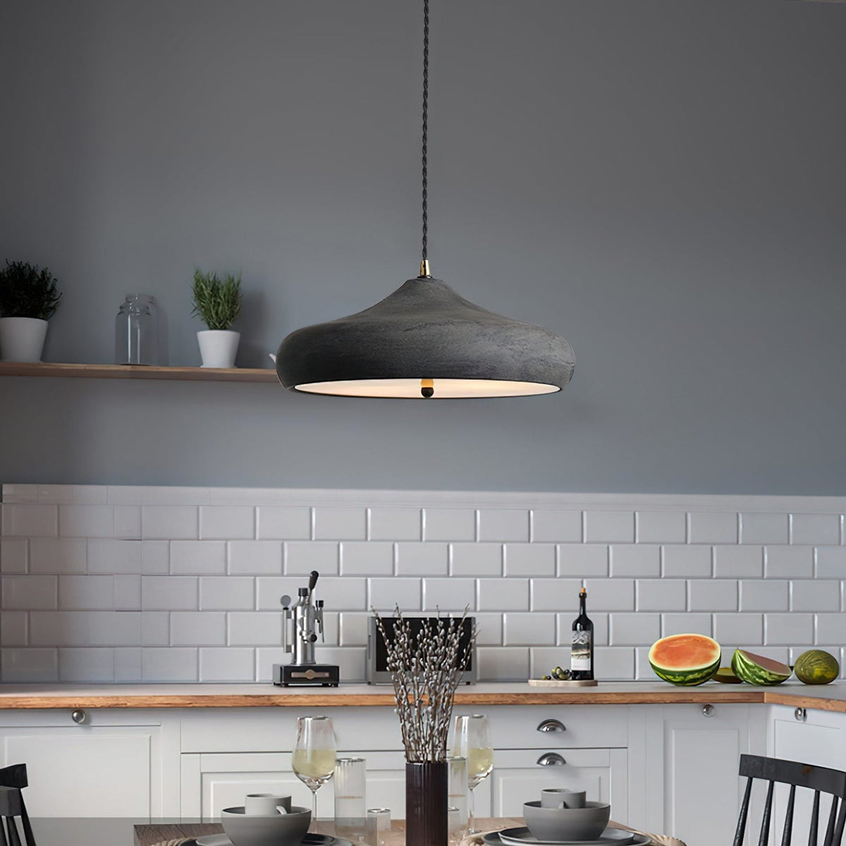 Curved dark iron pendant over a kitchen counter