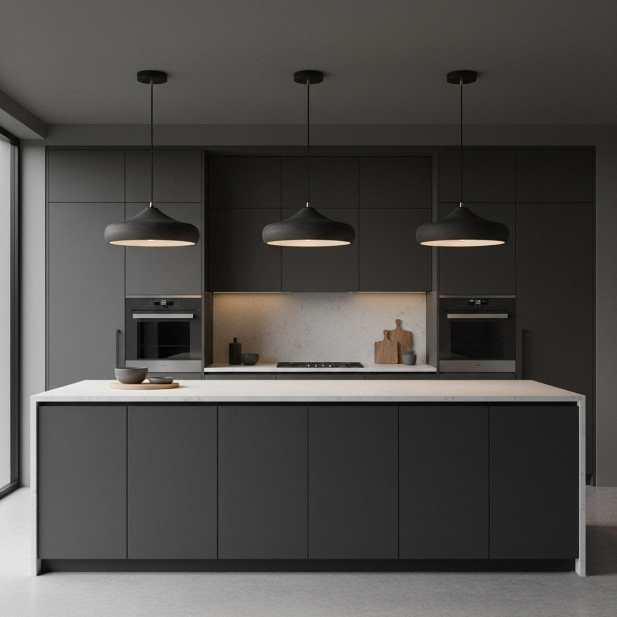 Three dark iron pendants above a kitchen island