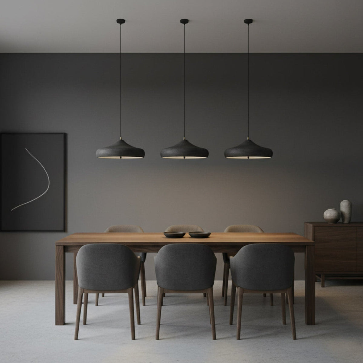 Three dark pendants above a timber dining table