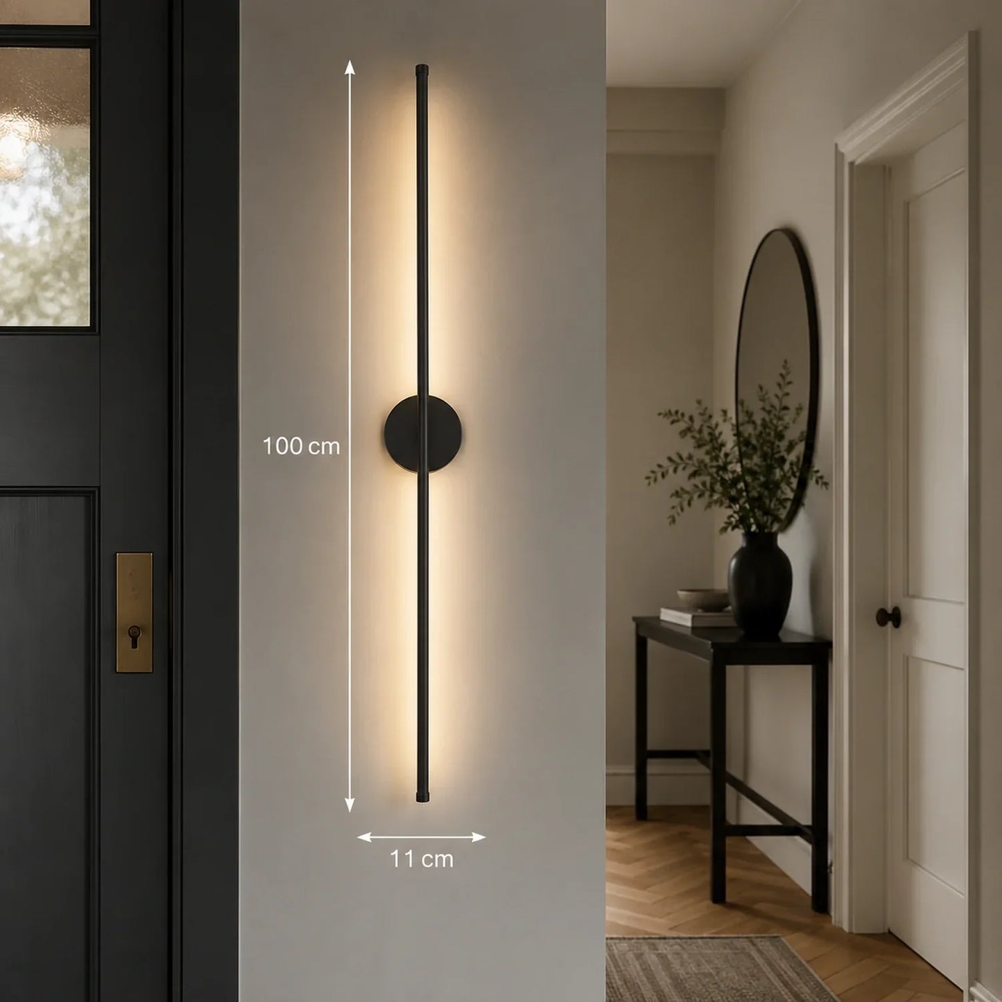 A 100cm black dimmable LED wall light mounted vertically in a hallway, featuring a sleek modern design with warm illumination and dimension markers.