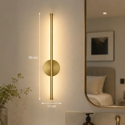 50cm gold dimmable LED wall light featuring a modern vertical design with touch control, mounted on a bedroom wall beside a mirror for ambient lighting.
