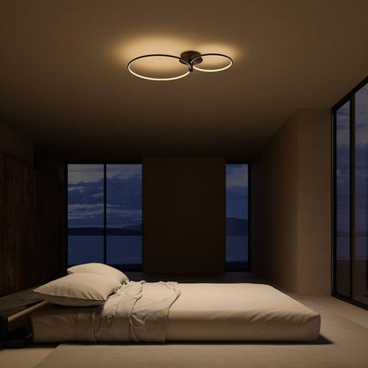 Black twin-ring LED ceiling light above a bedroom