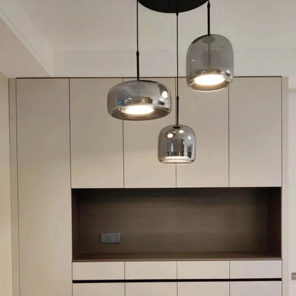 Grey three-light pendant set above a kitchen counter
