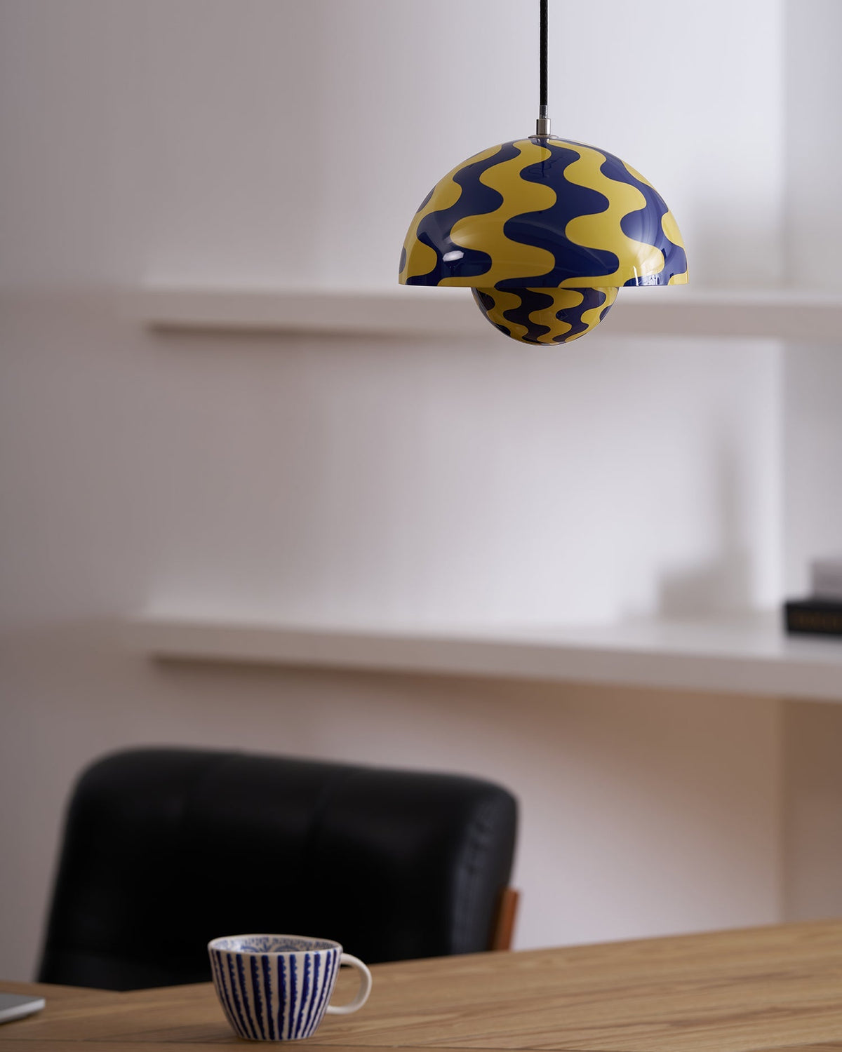 Patterned yellow and blue pendant beside shelving