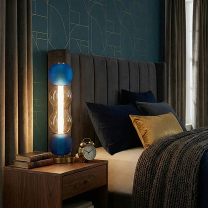 Blue and amber glass lamp on a bedside table