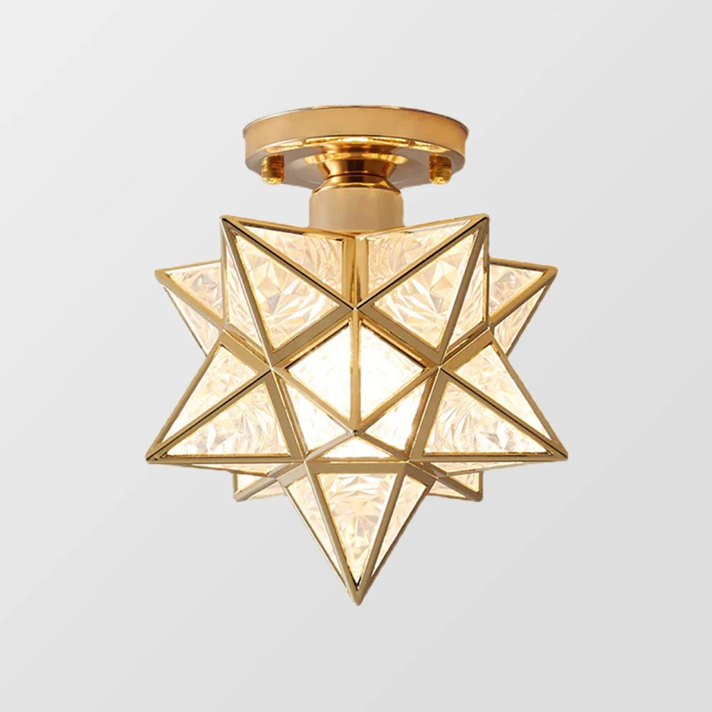 A modern five-pointed star flush mount ceiling light featuring a gold metal frame and faceted glass panels that create a warm, glowing indoor light.