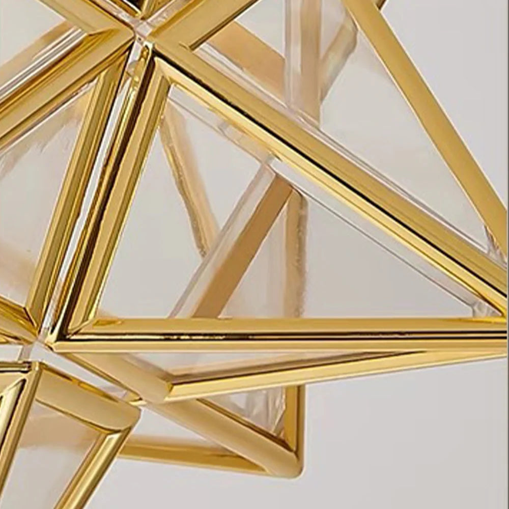 Close-up of a modern five-pointed star flush mount ceiling light featuring a geometric gold metal frame with clear glass panels for indoor lighting.