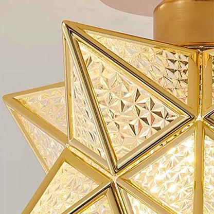 Close-up of a five-pointed star flush mount ceiling light featuring a gold metal frame and textured, geometric glass panels that diffuse warm light.