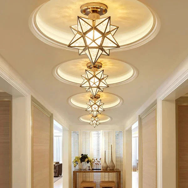 Gold five-pointed star flush mount ceiling lights arranged in a row along a modern hallway, casting a warm glow on the ceiling and interior decor.