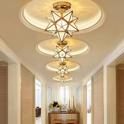 Gold five-pointed star flush mount ceiling lights arranged in a row along a modern hallway, casting a warm glow on the ceiling and interior decor.