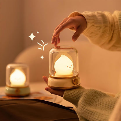 Hand touching the clear cover of a flame-shaped LED bedside lamp