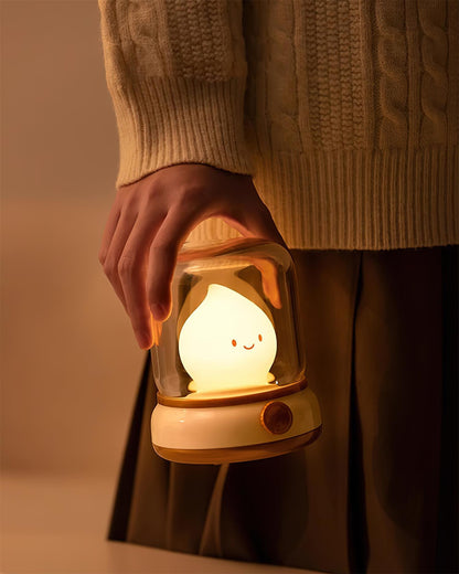 Beige lantern-style LED bedside lamp with glowing flame-shaped light 16