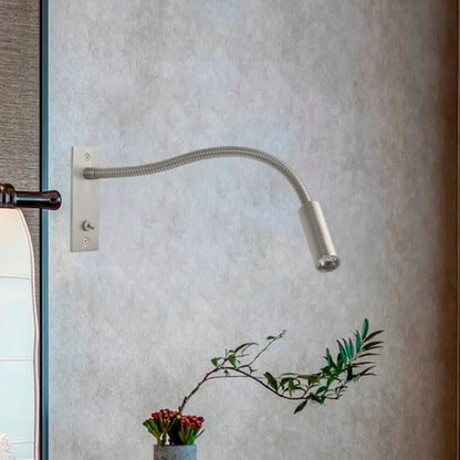 Flexible LED reading wall lamp with a metallic finish mounted on a textured wall, featuring an adjustable gooseneck arm for bedside lighting.