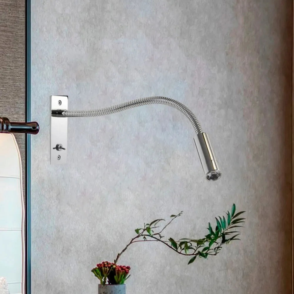 A sleek, chrome-finished flexible LED reading wall lamp mounted on a textured grey wall, perfect for modern bedside lighting and adjustable task focus.