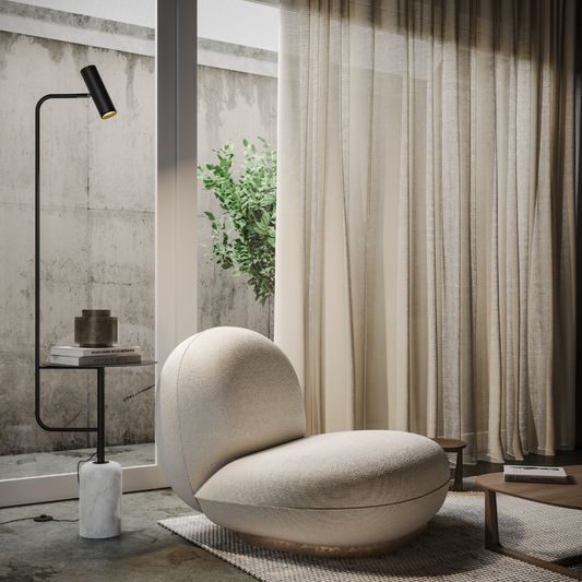 Black floor lamp with side table and marble-look base beside an armchair