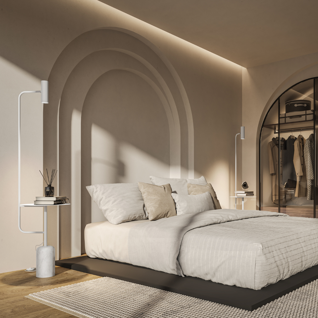 White floor lamp with table beside a bed in a bright bedroom