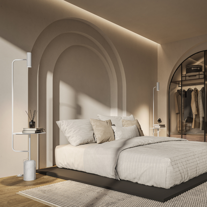 White floor lamp with table beside a bed in a bright bedroom