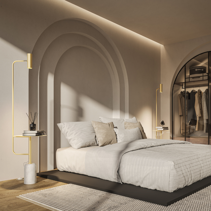Gold floor lamp with table beside a bed in a bright bedroom