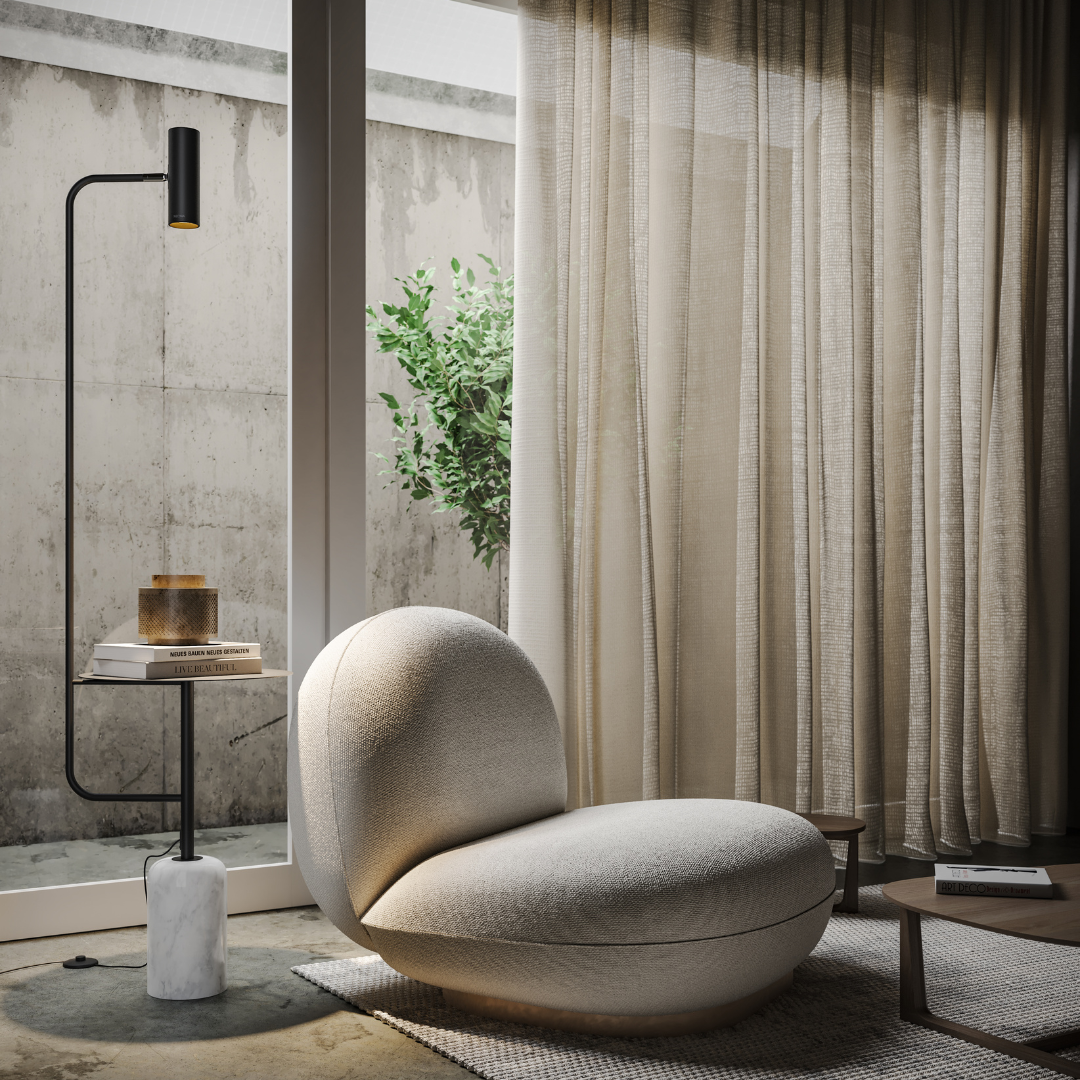 Black reading floor lamp with side table beside an armchair
