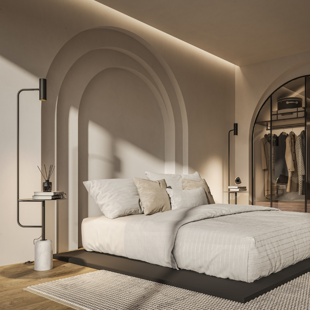 Black floor lamp with table beside a bed in a bright bedroom