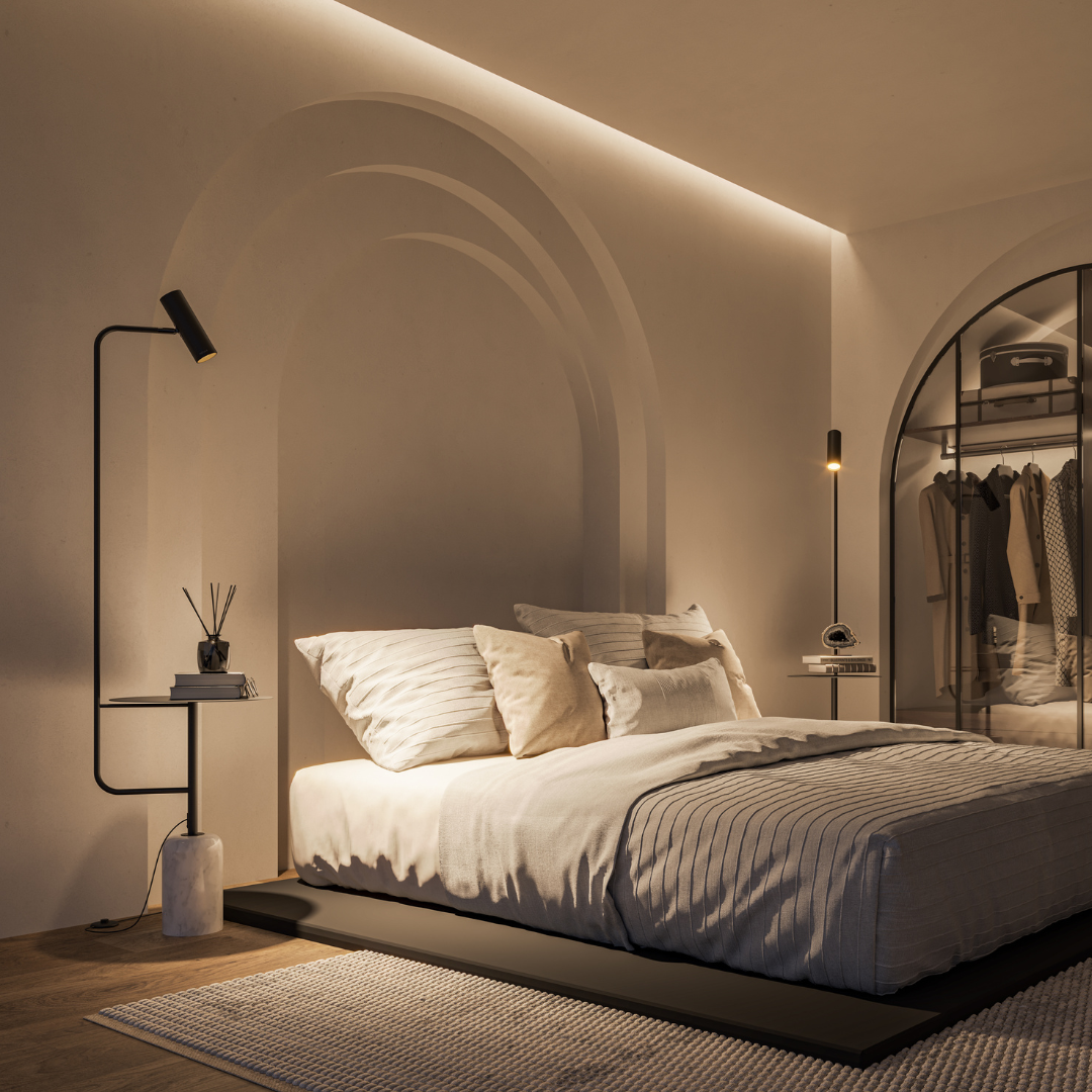 Black floor lamp with table illuminating a bedside area