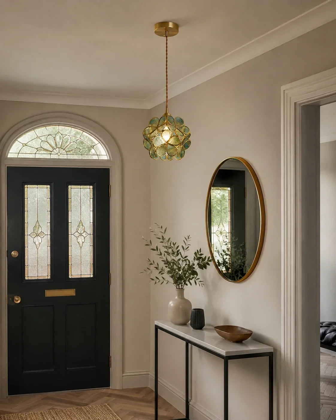 Floral glass petal pendant light with a warm brass finish hanging in a stylish hallway above a console table and oval mirror, creating a cosy glow.
