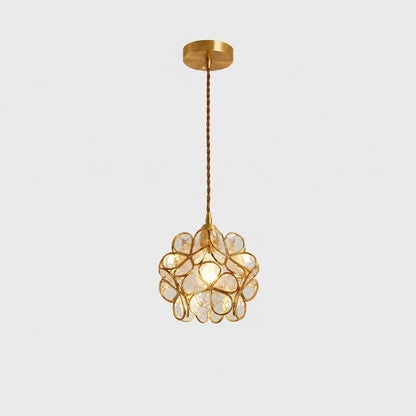Floral glass petal pendant light in transparent A finish with a warm glowing bulb, suspended by a twisted cable from a circular copper ceiling rose.