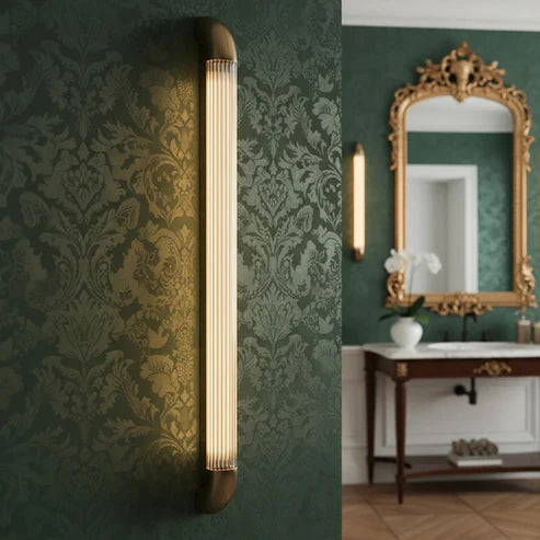 Warm fluted wall light beside a decorative mirror