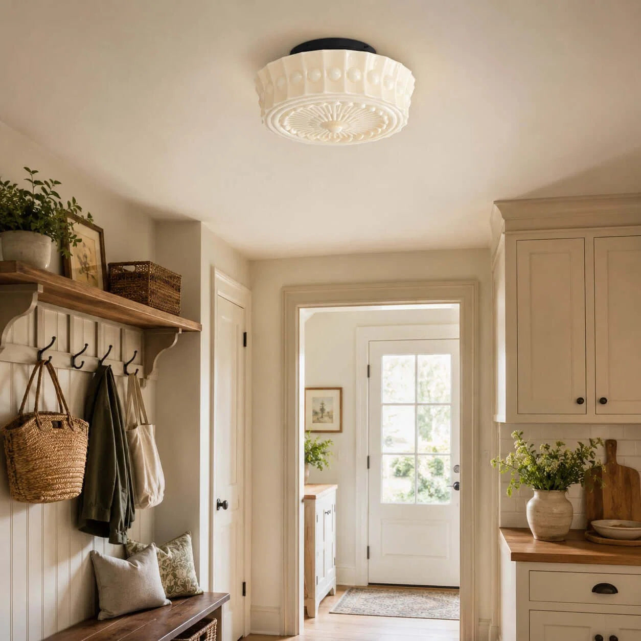 A French vintage style flushmount ceiling fixture with a decorative glass shade installed in a bright, traditional hallway with neutral decor.