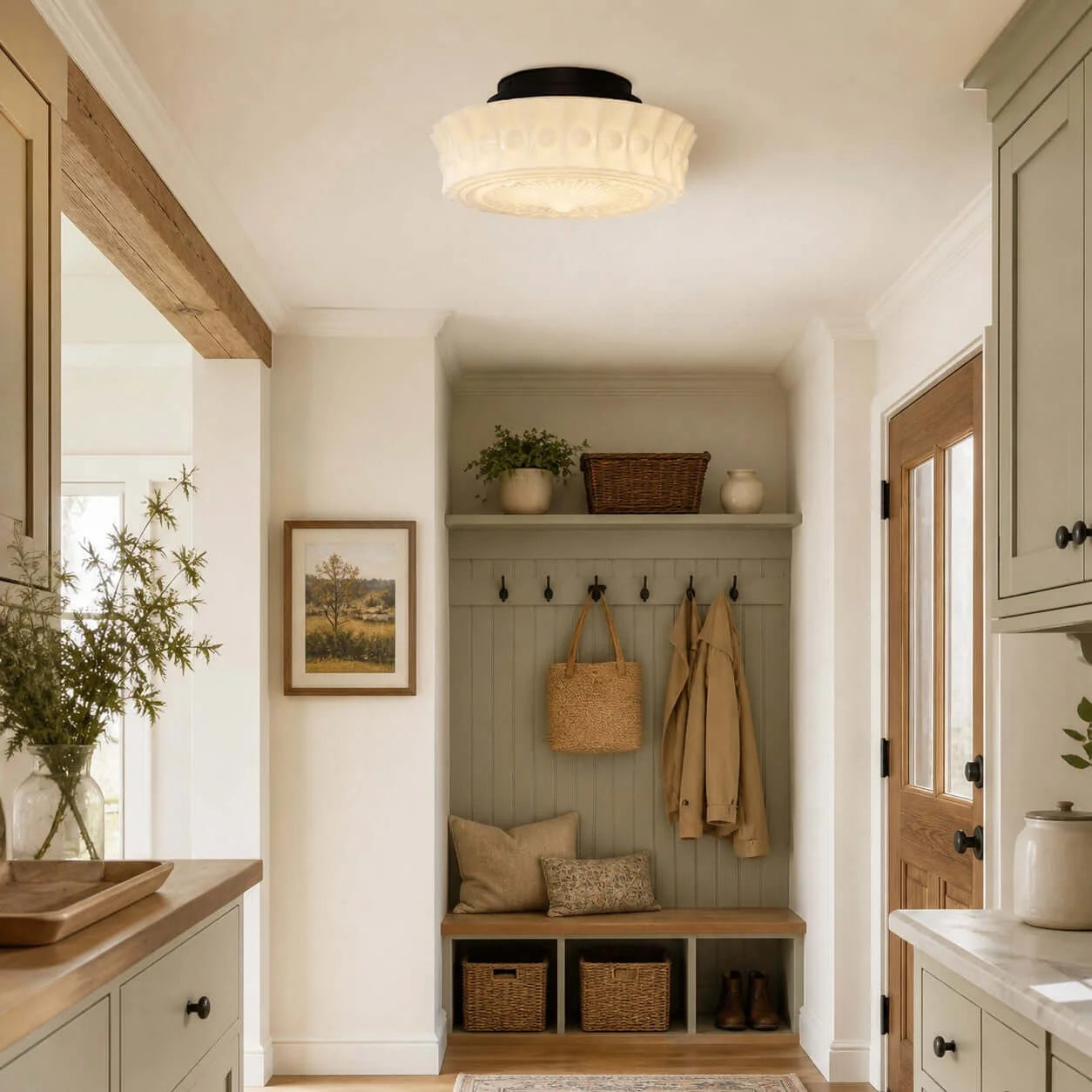 French vintage flushmount ceiling light with a textured glass shade installed in a bright, traditional hallway with sage green cabinetry and decor.