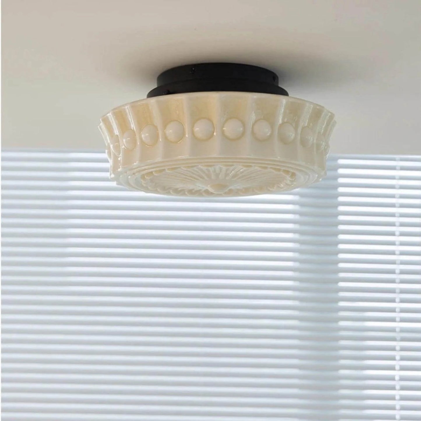 French vintage style flushmount ceiling light featuring a decorative cream glass shade with a textured beaded rim and a black circular base fitting.