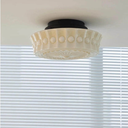 French vintage style flushmount ceiling light featuring a decorative cream glass shade with a textured beaded rim and a black circular base fitting.