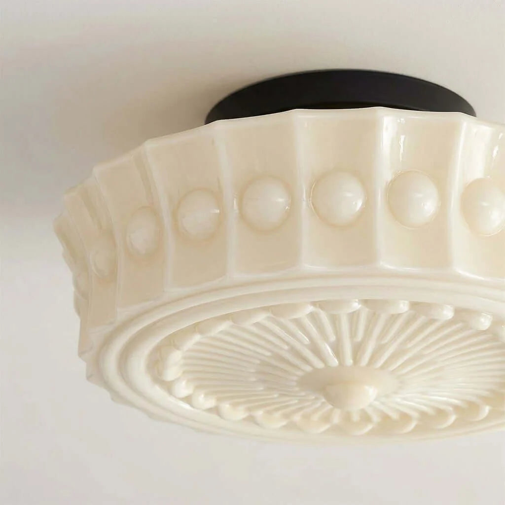 French vintage flushmount ceiling fixture featuring a cream-coloured fluted glass shade with embossed dot detailing and a dark circular base mount.